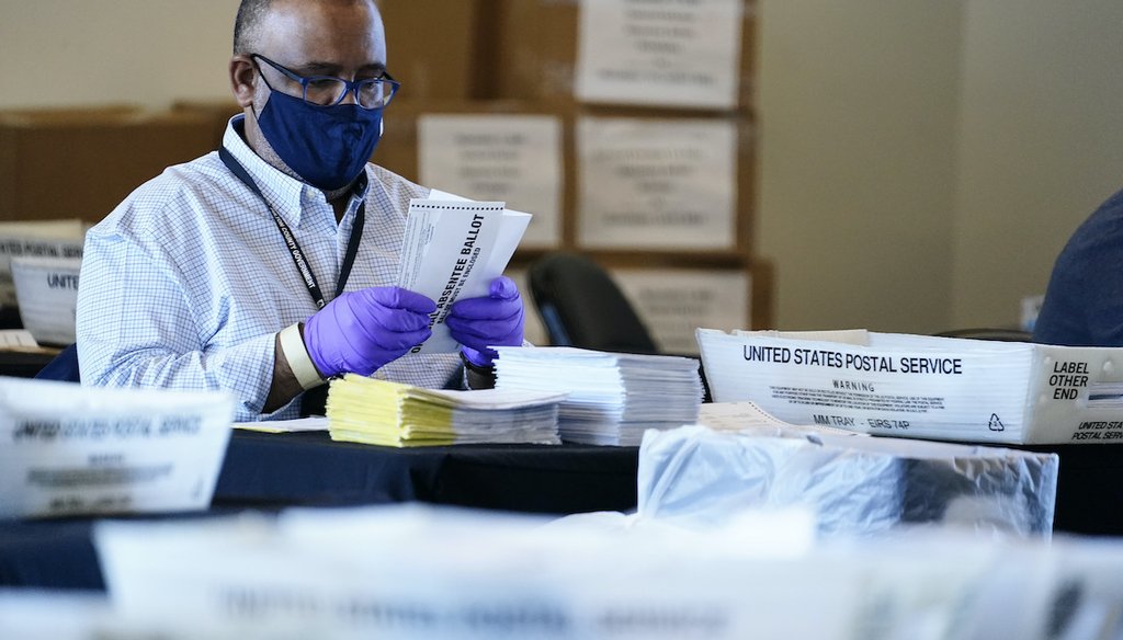An election inspector looks at an absentee ballot as vote counting in the general election continues at State Farm Arena, Wednesday, Nov. 4, 2020, in Atlanta. (AP)