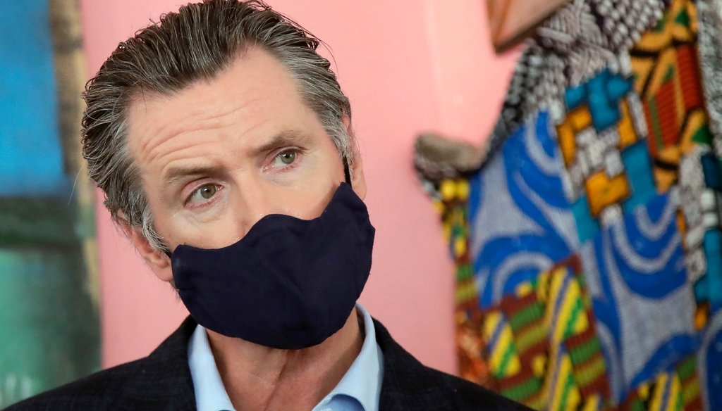 Gov. Gavin Newsom wears a protective mask on his face while speaking to reporters at a restaurant during the coronavirus outbreak in Oakland, Calif., Tuesday, June 9, 2020. AP Photo/Jeff Chiu