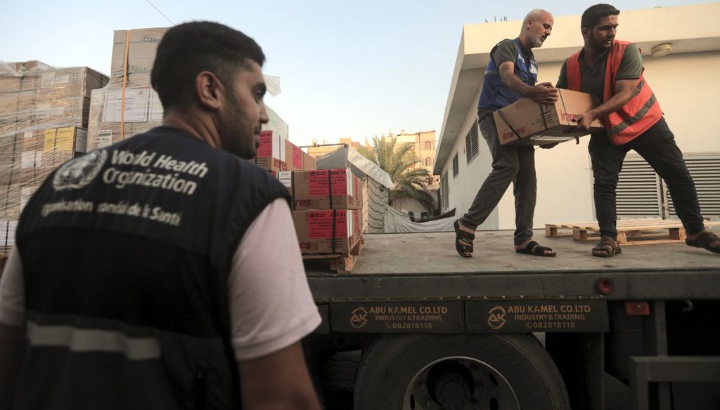Palestinians unload boxes of medicine from a truck at Egypt's border with Gaza on Oct. 23, 2023. (AP)