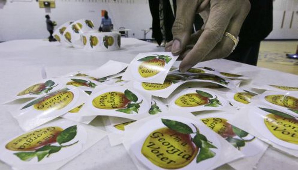 Are you a Georgia voter? Poll worker Syer Owens puts out voting stickers at E. Rivers Elementary School in Atlanta Super Tuesday.