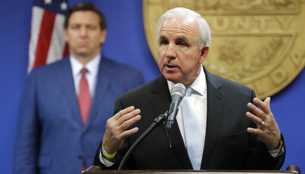 Miami-Dade County Mayor Carlos Gimenez, right, speaks during a news conference with Florida Gov. Ron DeSantis, rear, at the Miami-Dade Emergency Operations Center, Monday, June 8, 2020, in Doral, Fla. (AP)