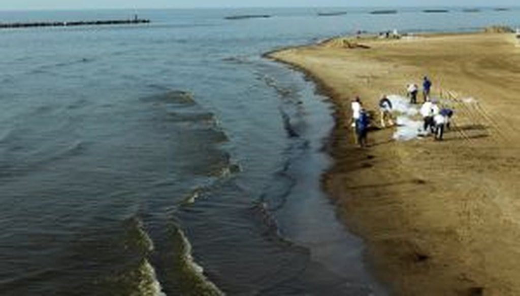 Workers clean the beach at Grand Isle, La., on June 16, 2010.