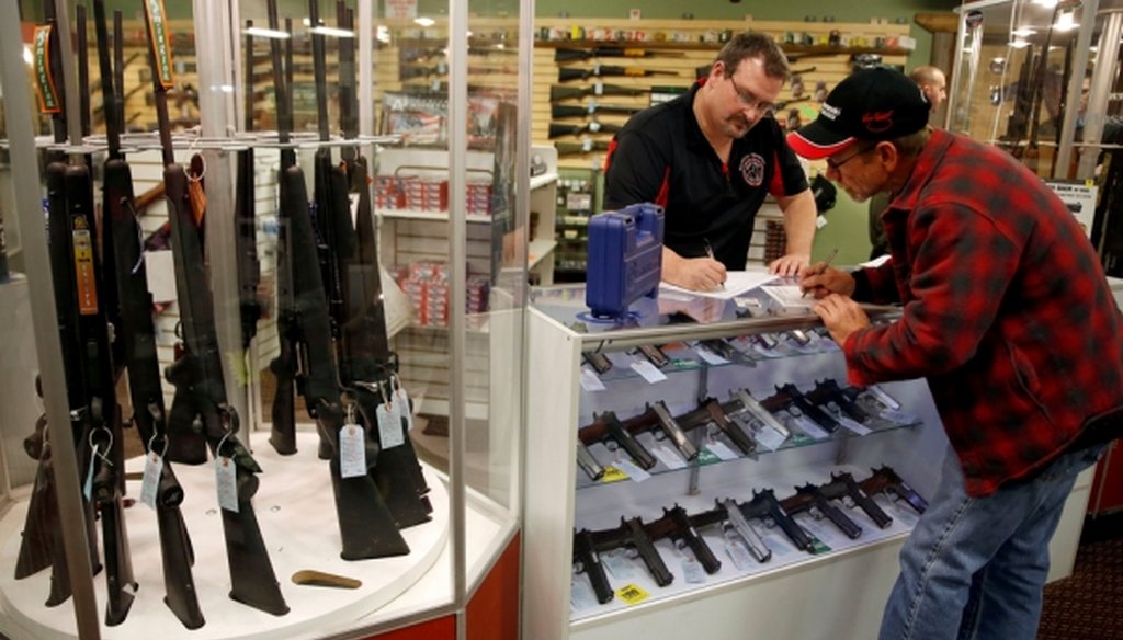 Steven King, left, fills out paperwork before selling a handgun to first-time gun owner Dave Benne at Metro Shooting Supplies, in Bridgeton, Mo., in 2014. (AP/Jeff Roberson) 