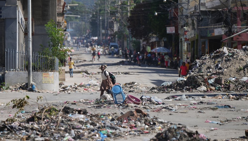 A youth crosses a street littered with garbage in downtown in Port-au-Prince, Haiti, Jan. 20, 2026. (AP)