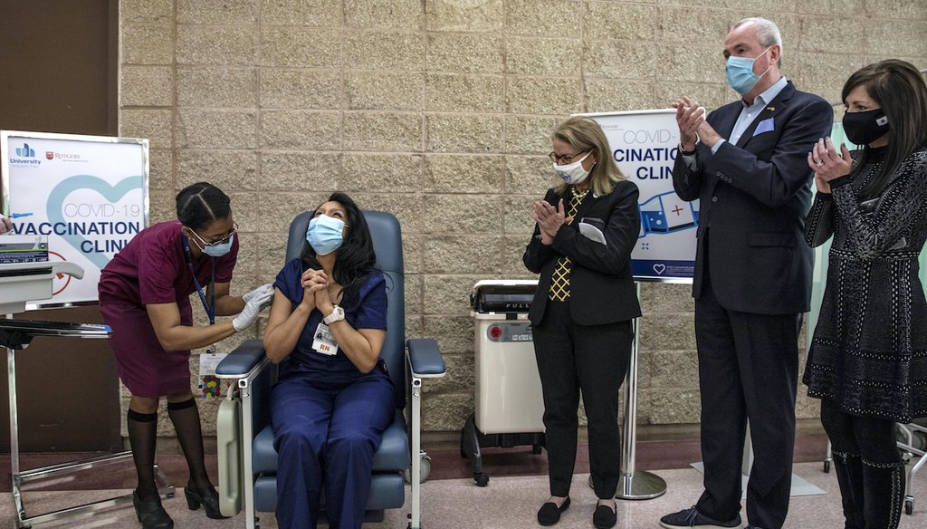 New Jersey Gov. Phil Murphy, second from right, watches as nurse Maritza Beniquez, seated, reacts after being the first in the state to receive the Pfizer-BioNTech COVID-19 vaccine, at University Hospital, in Newark, NJ, Tuesday Dec. 15, 2020. (AP)