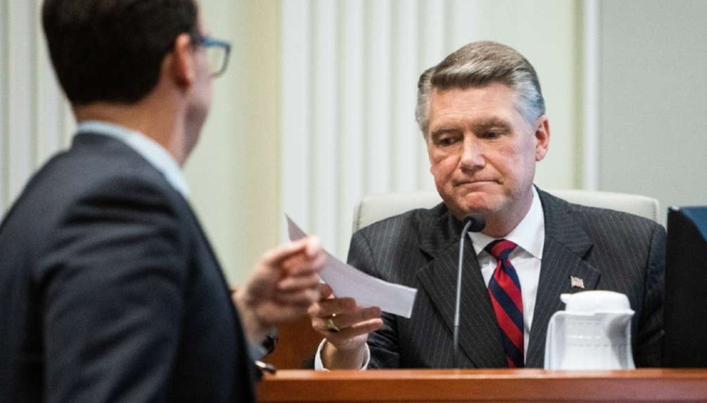 Josh Lawson, chief counsel for the NC elections board, hands Republican Mark Harris a document during the fourth day of a public evidentiary hearing on the 9th Congressional District race on Feb. 21.