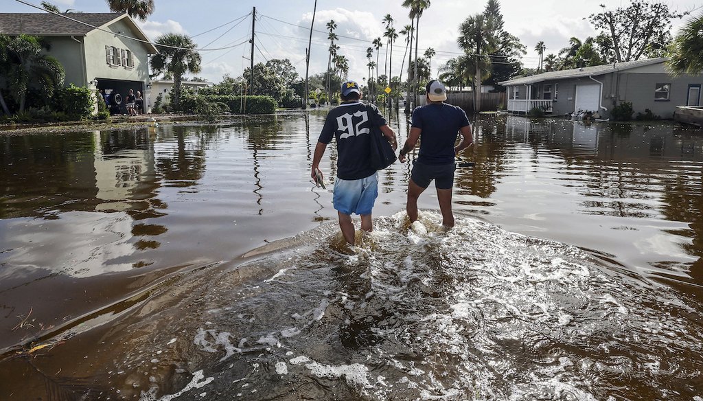 Thomas Chaves, izquierda, y Vinny Almeida caminan a través de las aguas del huracán Helene en un intento de llegar a la casa de la madre de Chaves en el barrio de Shore Acres, el 27 de septiembre 2024, en San Petersburgo, Florida. (AP)