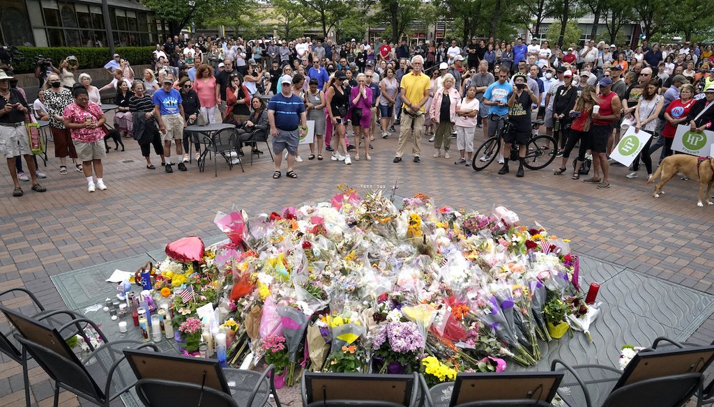 Local Highland Park, Illinois, residents stand for a two-minute moment of silence at 10:14 a.m. on July 11, 2022, in memory of the seven people who lost their lives during the town's Fourth of July parade. (AP)