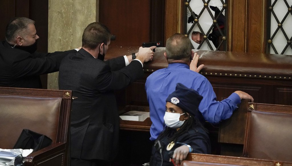 U.S. Capitol Police officers with guns drawn as rioters try to break into the House Chamber at the U.S. Capitol on Jan. 6. (AP)