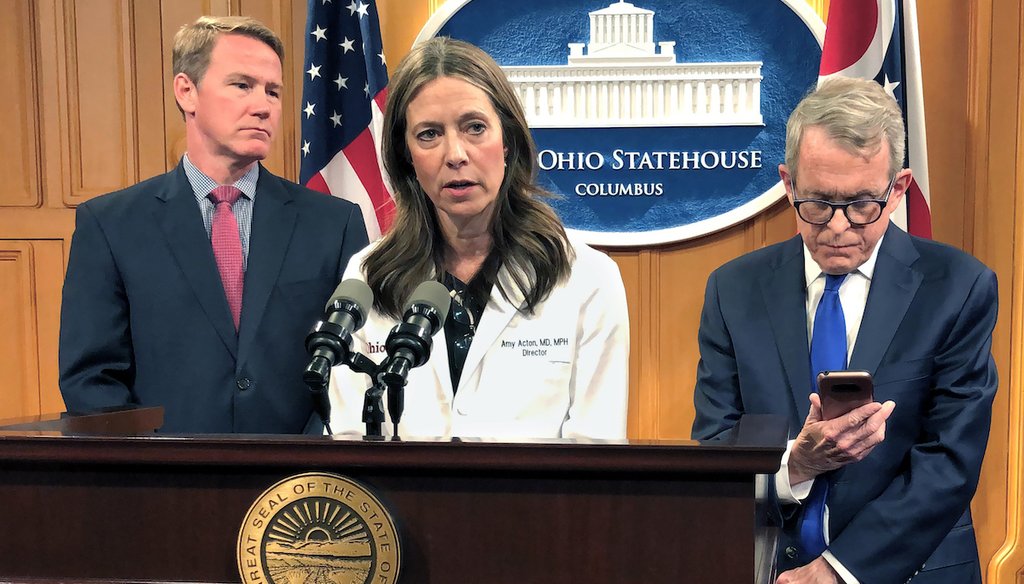 Dr. Amy Acton, Ohio Department of Health Director, center, discusses the confirmation of Ohio's first three cases of coronavirus, as Gov. Mike DeWine, right, studies an update on the cases provided to him during a news conference, March 9, 2020. (AP)