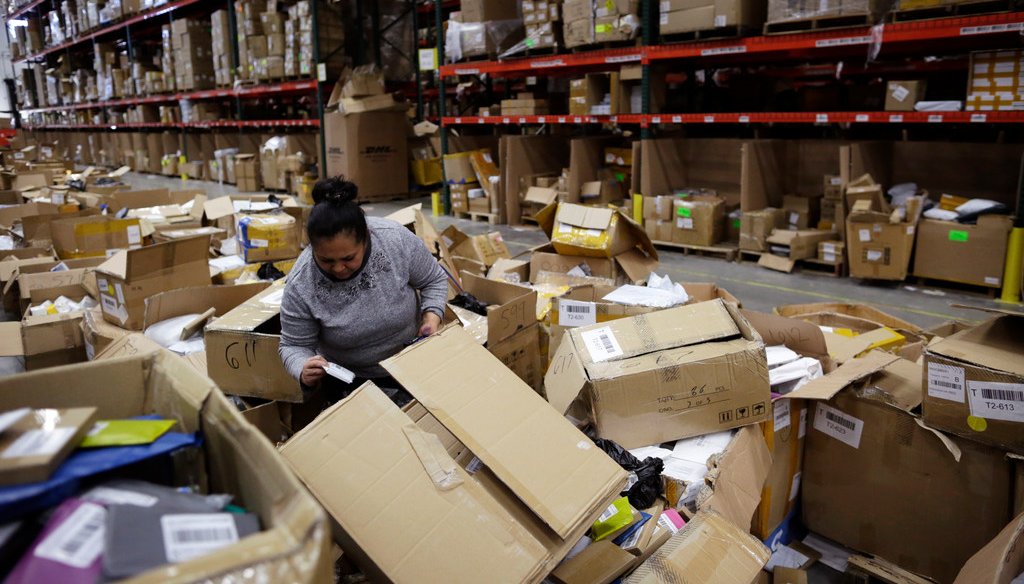 An employee sorts through boxes at the Win.It America warehouse in Walton, Ky., on May 1, 2018. After an ICE agent arrested one of the company's employees, the warehouse lost 28 workers over several weeks and struggled to meet its shipping deadline. (AP)