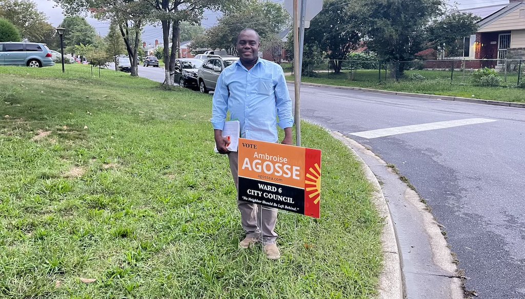 Takoma Park Ward 6 city council candidate Ambroise Agosse stands next to a yard sign during door-to-door canvassing Sept. 27, 2024. (PolitiFact/Kwasi Gyamfi Asiedu)