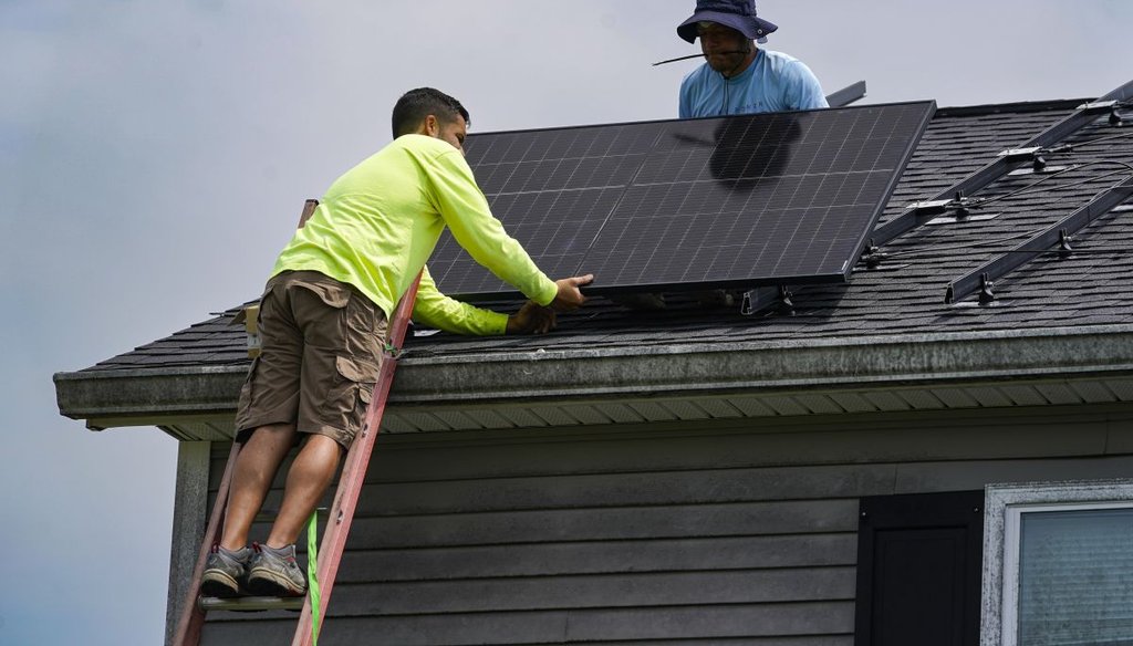 Brian Hoeppner, right, and Nicholas Hartnett, owner of Pure Power Solar, install a solar panel on the roof of a home in Frankfort, Ky., on July 17, 2023. (AP)