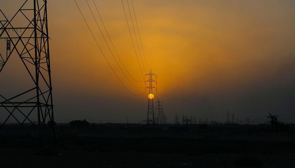 The sun sets behind the transmission lines of electric power from Iran to Iraq in Basra, Iraq, in 2021. (AP)