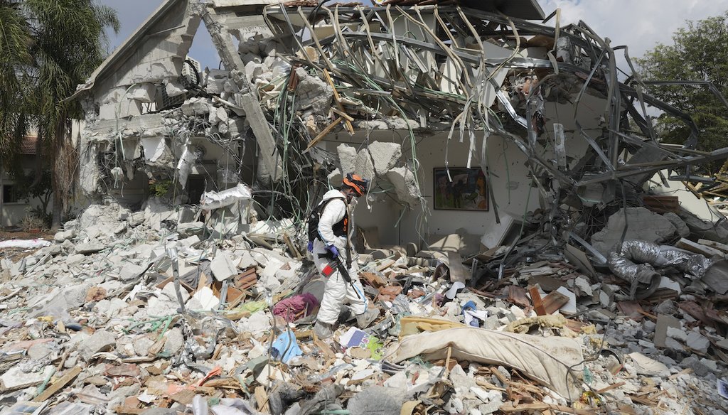 An Israeli soldier walks past a house destroyed by Hamas militants in Kibbutz Be'eri on Wednesday, Oct. 11, 2023. (AP)