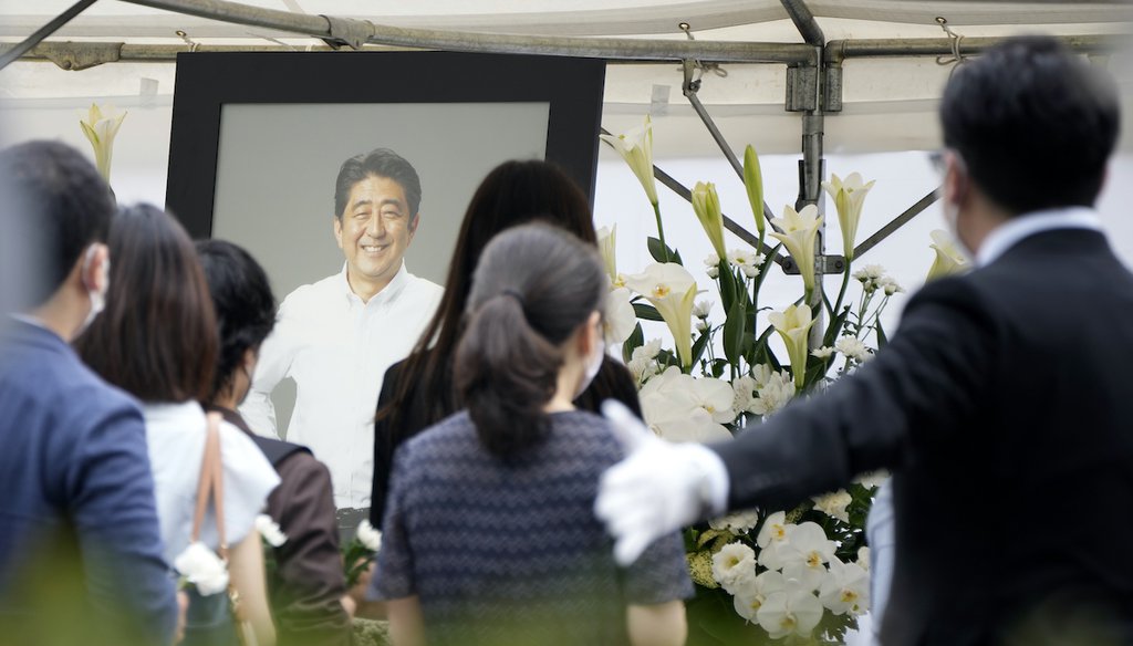 People queue to offer flowers and prayers for former Prime Minister Shinzo Abe, at Zojoji temple prior to his funeral Tuesday, July 12, 2022, in Tokyo. (AP)