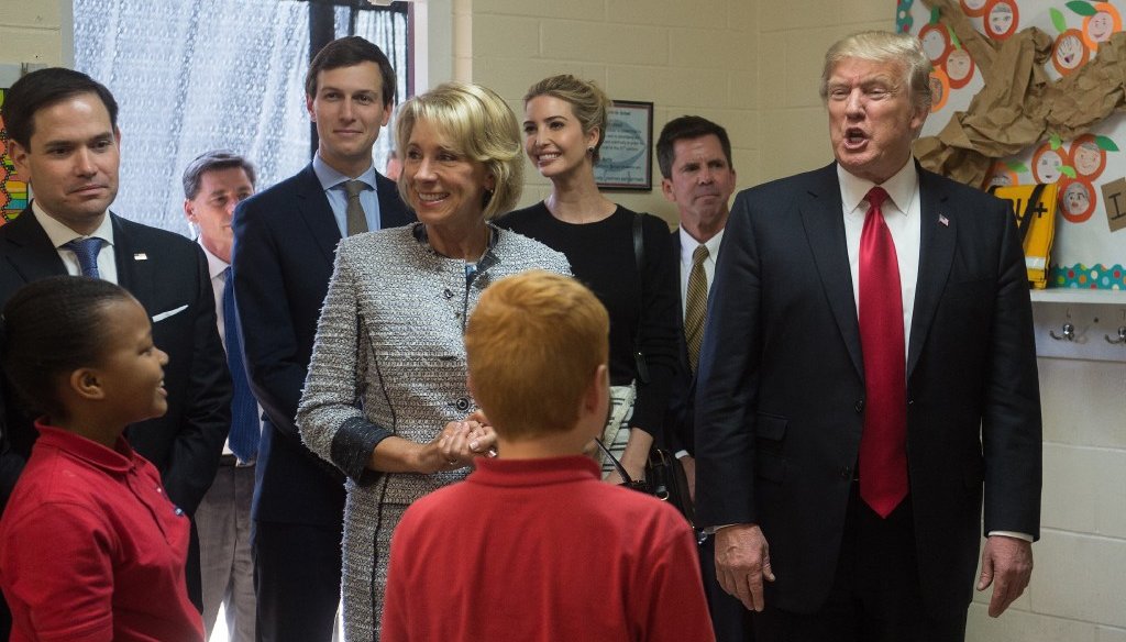 Presidential senior adviser Jared Kushner (blue shirt); his wife and President Donald Trump's daughter, Ivanka Trump (next to Kushner); and Donald Trump (far right) visited a school in Orlando, Fla., on March 3, 2017. (AFP)