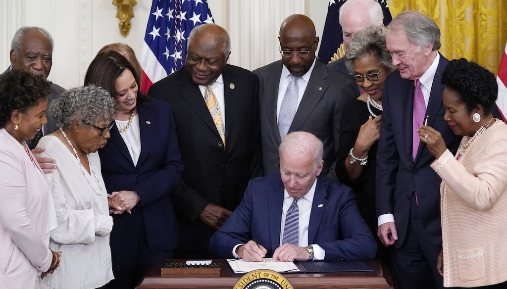 President Joe Biden signs the Juneteenth National Independence Day Act, at the White House on June 17, 2021, surrounded Vice President Kamala Harris and members of Congress. (AP)