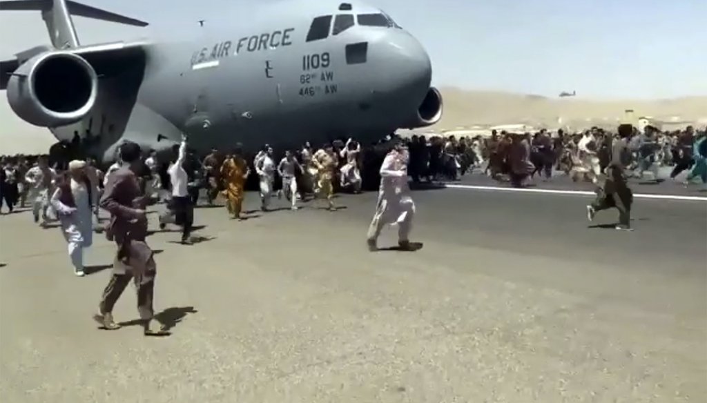 In this Aug. 16, 2021 photo, hundreds of people run alongside a moving U.S. Air Force C-17 transport plane at the Kabul, Afghanistan, international airport. A similar image taken at the scene is being falsely characterized in some social media posts. (AP)