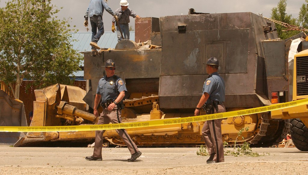 Two Colorado State Patrol troopers keep the area around an armored bulldozer secure after it was removed from the Gambles Hardware store rubble in Grandby, Colo. in this 2004 file photo. (AP)