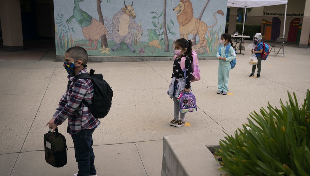 Socially distanced kindergarten students wait for their parents to pick them up on the first day of in-person learning at Maurice Sendak Elementary School in Los Angeles, Tuesday, April 13, 2021. (AP)