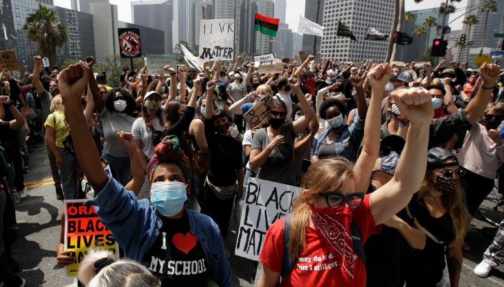 Demonstrators raise their fists during a protest to demand the defunding of the Los Angeles school district police outside of the school board headquarters June 23, 2020, in Los Angeles. (AP)