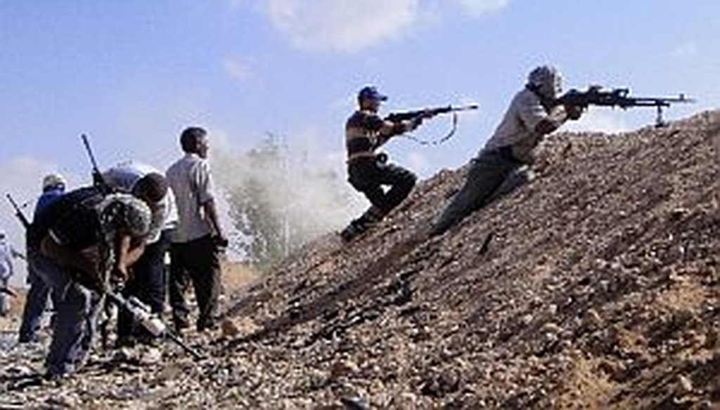 Libyan rebel fighters fire their machine guns towards pro-Gadhafi forces. The U.S. and NATO are enforcing a no-fly zone.