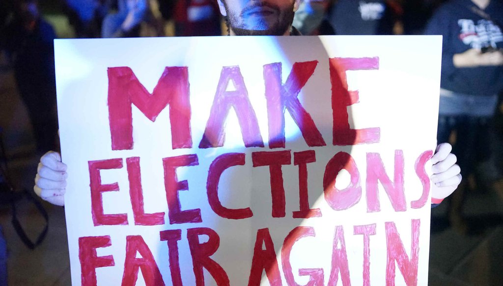 A Trump supporter holds up a sign during a protest outside the TCF Center on Thursday, Nov. 5, 2020, in Detroit. A judge dismissed a challenge from the Trump campaign to stop ballot counting in Michigan. (Antranik Taviti, Detroit Free Press)