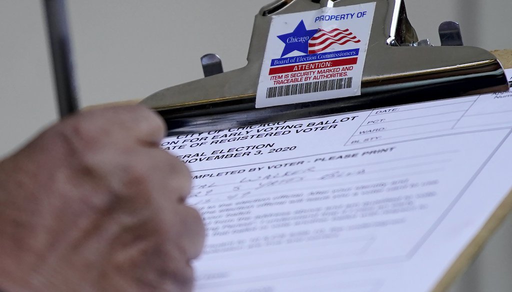 A man fills out voter registration card outside the Loop Super Site in downtown Chicago, Oct. 11, 2020. (AP)