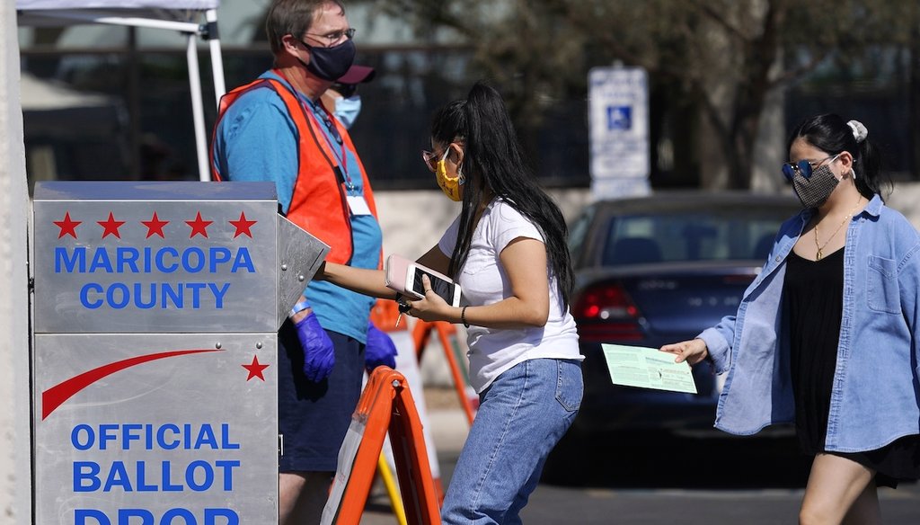 Voters drop off ballots as volunteers look on at the Maricopa County Recorder's Office on Oct. 20, 2020, in Phoenix. (AP)