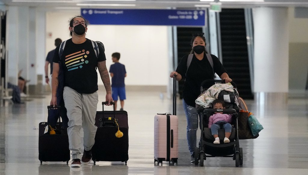 Masked travelers walk through the Los Angeles International Airport, April 25, 2022. (AP Photo)