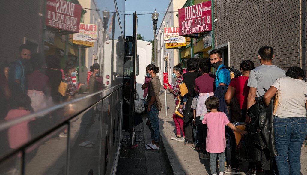 A group of migrants wait to board a charter bus in front of the Catholic Charities RGV Humanitarian Respite Center in McAllen on Tuesday, July 27, 2021.