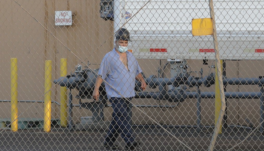 A worker wears a mask as he walks behind a fence at Agri Beef's Washington Beef processing plant in Toppenish, Wash., on May 7, 2020. (AP)