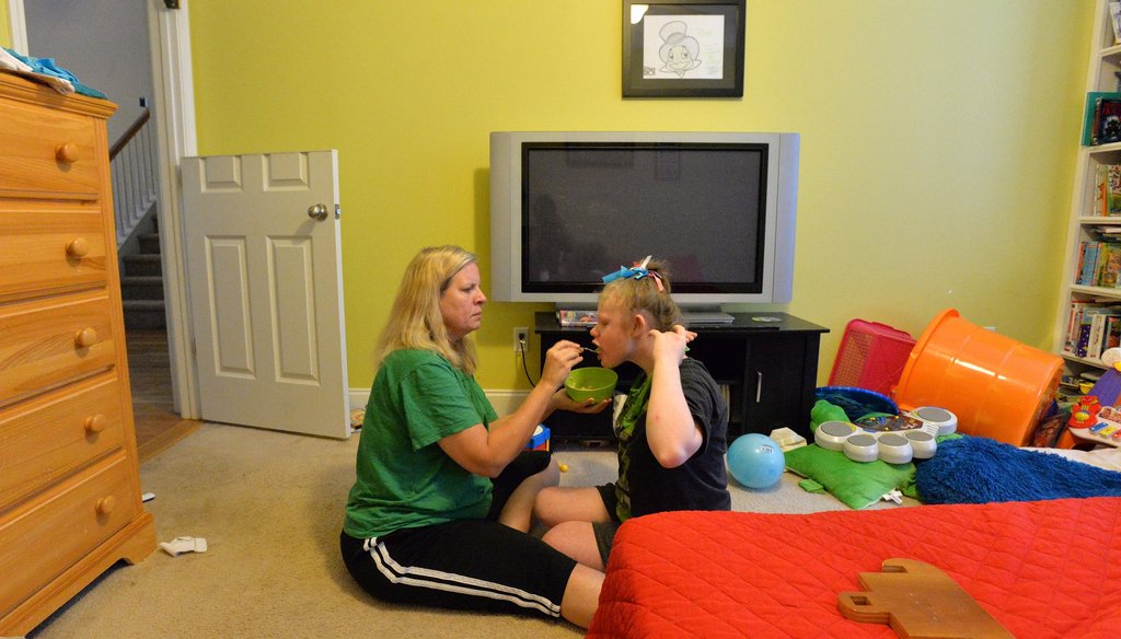 Kelli Hopkins feeds her daughter Michala, 16, in their Covington home in September. Michala suffer from a seizure disorder that could be treated by cannabis-based oil that may become legal in Georgia. 
