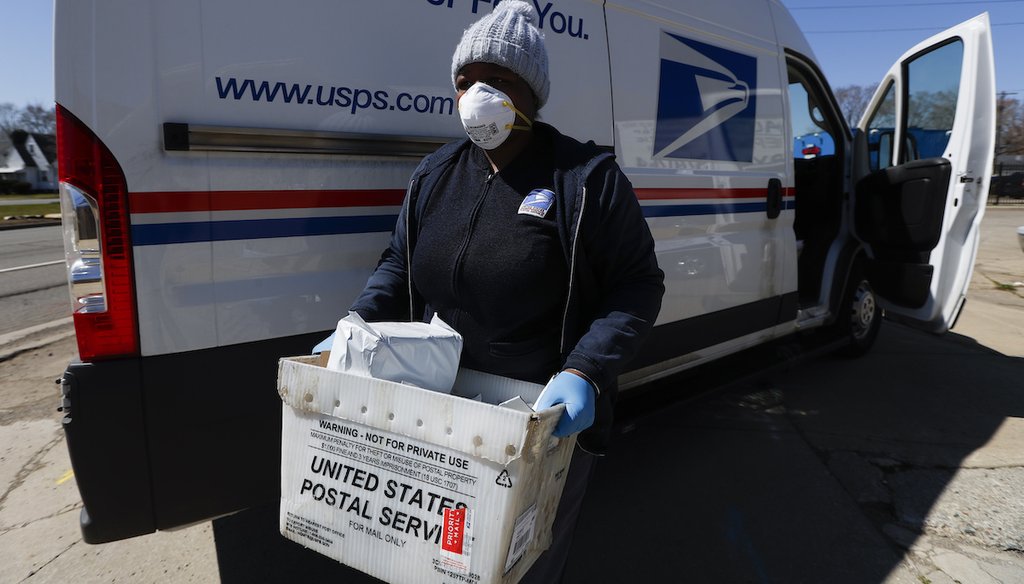A United States Postal worker makes a delivery with gloves and a mask in Warren, Mich., April 2, 2020. (AP)