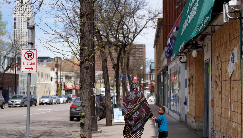 A woman and a child hold hands as they walk down a street in the predominantly Somali neighborhood of Cedar-Riverside in Minneapolis on May 12, 2022. (AP)