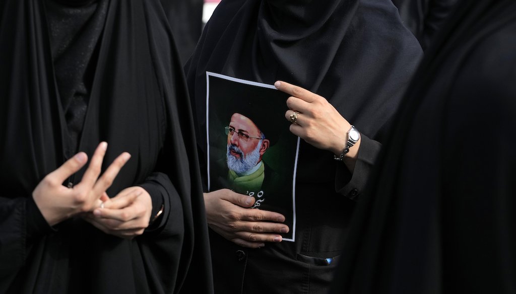 An Iranian woman holds a poster of President Ebrahim Raisi during a mourning ceremony for him at Vali-e-Asr square in downtown Tehran, Iran on  May 20, 2024. (AP)
