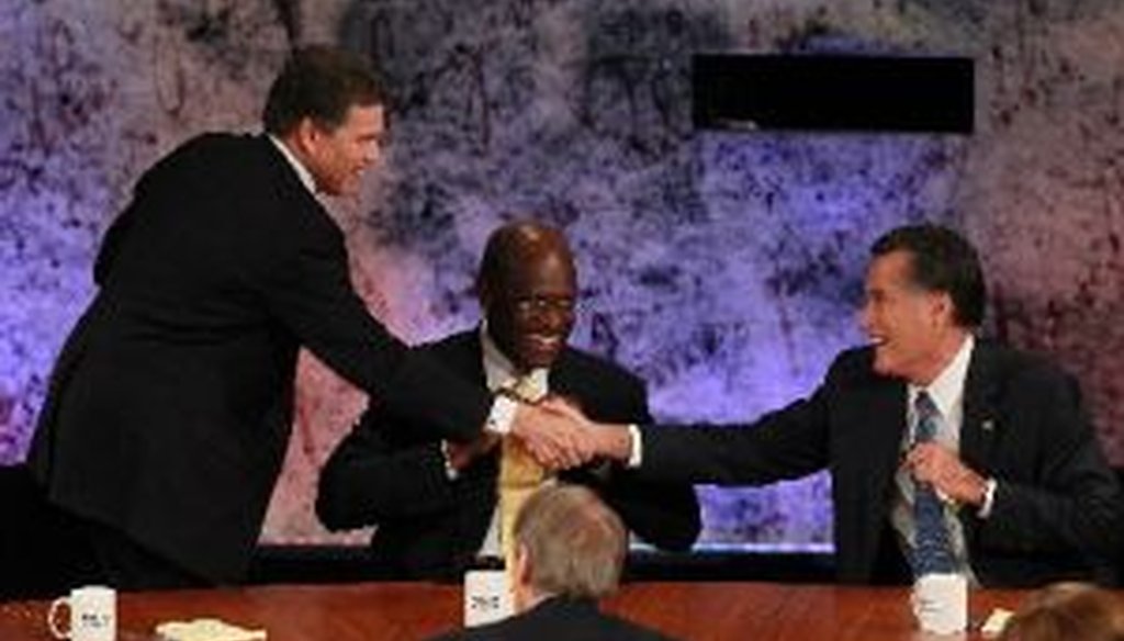As Herman Cain looks on, Rick Perry and Mitt Romney shake hands at the conclusion of the Republican Presidential debate at Dartmouth College in Hanover, N.H.