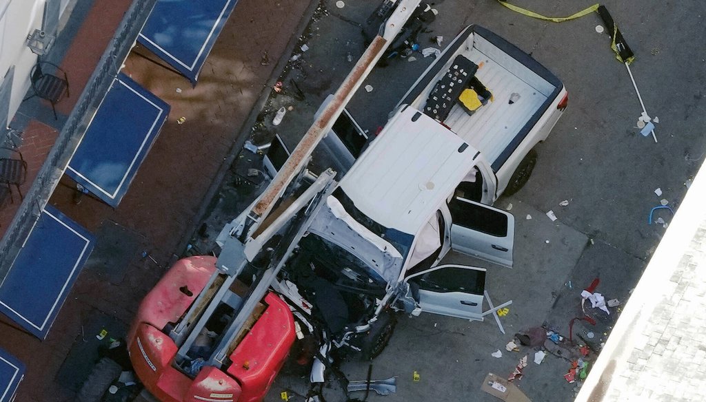 A black flag with white lettering lies on the ground rolled up behind a pickup truck that a man drove into a crowd on Bourbon Street in New Orleans, killing and injuring a number of people early on Jan. 1, 2025. (AP)