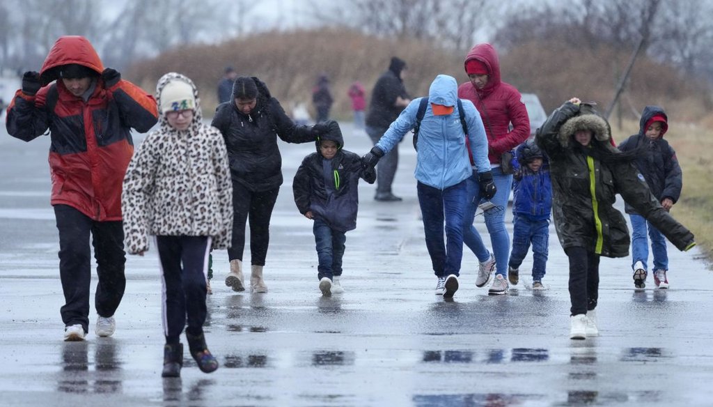 Migrants run in the rain Jan. 9, 2024, at a migrant housing location in New York City. (AP)