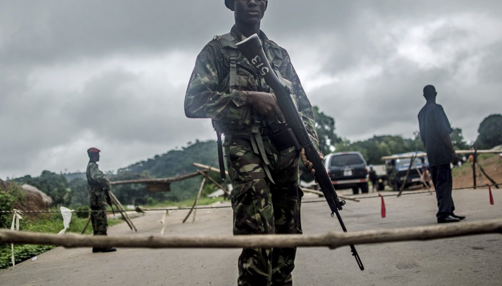 Soldiers stand guard at a roadblock outside Kenema, Sierra Leone, Aug. 8, 2014. (New York Times)