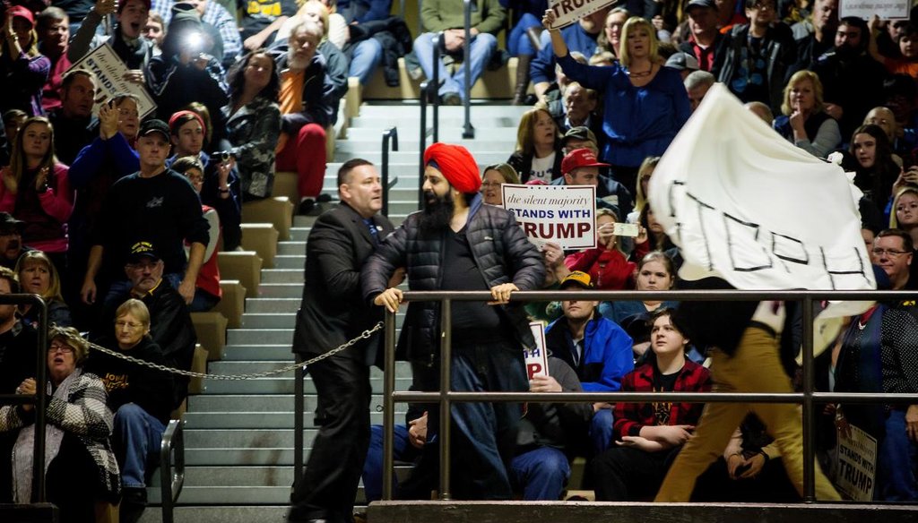 Two protesters are escorted from an event for Donald Trump at Muscatine High School in Muscatine, Iowa, Jan. 24, 2016. (Eric Thayer/The New York Times) 
