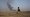 A member of an Arab tribal militia fighting the Islamic State watches as smoke rises from a crude oil refinery in Tel al-ail, Syria on Oct. 24, 2015 (New York Times). 