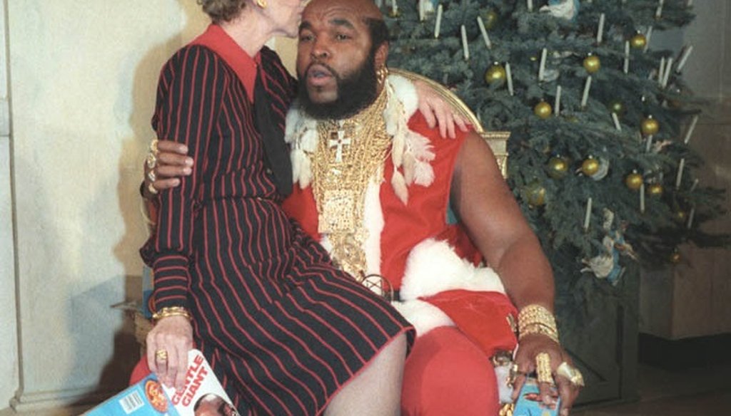 First Lady Nancy Reagan sits on the knee of television personality Mr. T, dressed as Santa Claus in 1983. (Wikipedia photo)