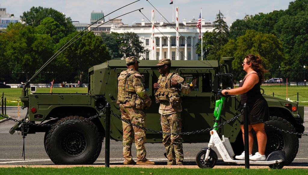 Members of the District of Columbia National Guard patrol in front of the White House as a woman rides past on a scooter, Aug. 16, 2025, in Washington. (AP)