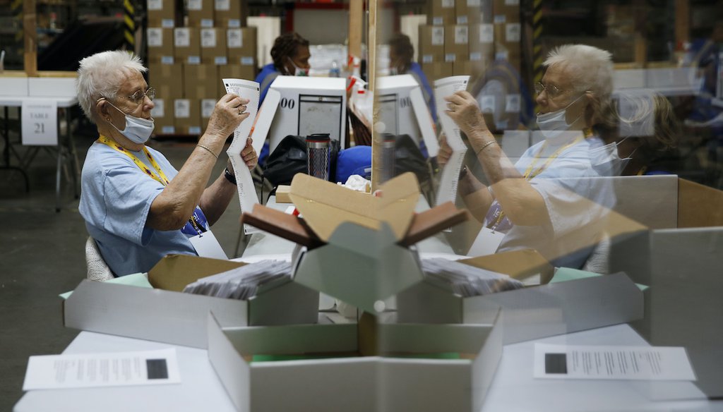 In this June 9, 2020, file photo election workers process mail-in ballots during a nearly all-mail primary election in Las Vegas.