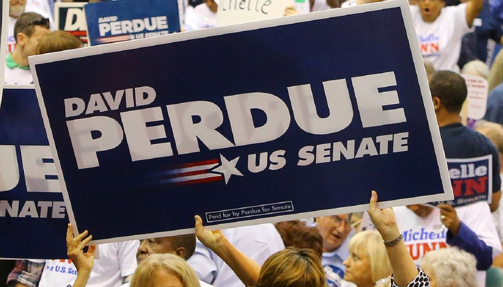 Supporters of David Perdue and Michelle Nunn wave signs just before the U.S. Senate debate at the Georgia National Fair on Oct. 7. Photo by Curtis Comptom/AJC.