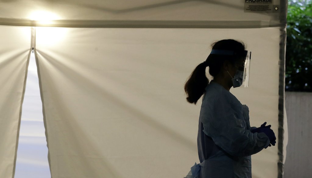 A nurse stands outside a drive-up coronavirus testing station at the University of Washington Medical Center. (AP Photo/Ted S. Warren)