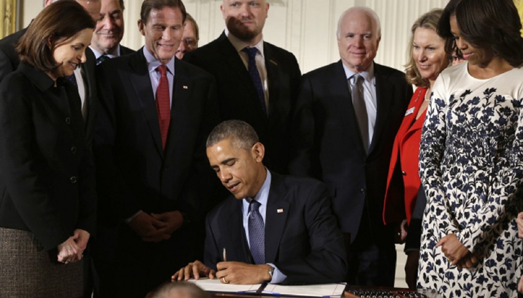 Georgia Republican Sen. Johnny Isakson, in the back row, looks on as President Barack Obama signs the Clay Hunt Suicide Prevention for American Veterans Act. (AP file photo)