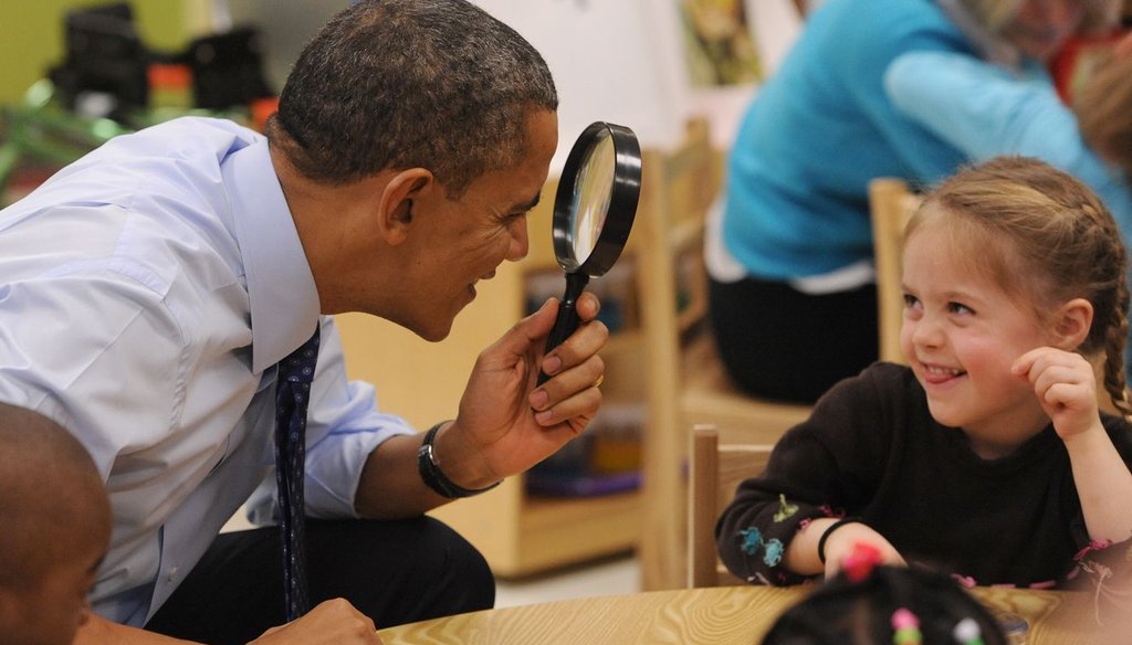 President Barack Obama playfully peers through a magnifying lens at a child while visiting an early care center in Decatur, Ga. Obama wants to devote more federal resources to programs like these.